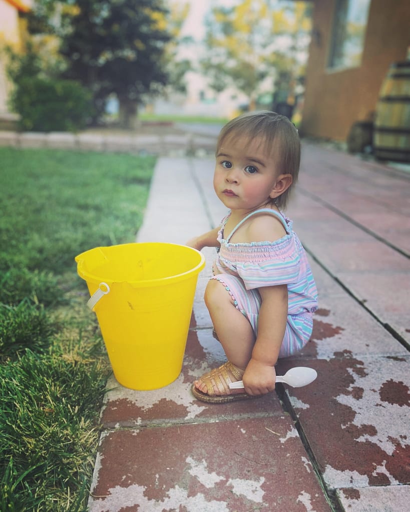 toddler with water bucket